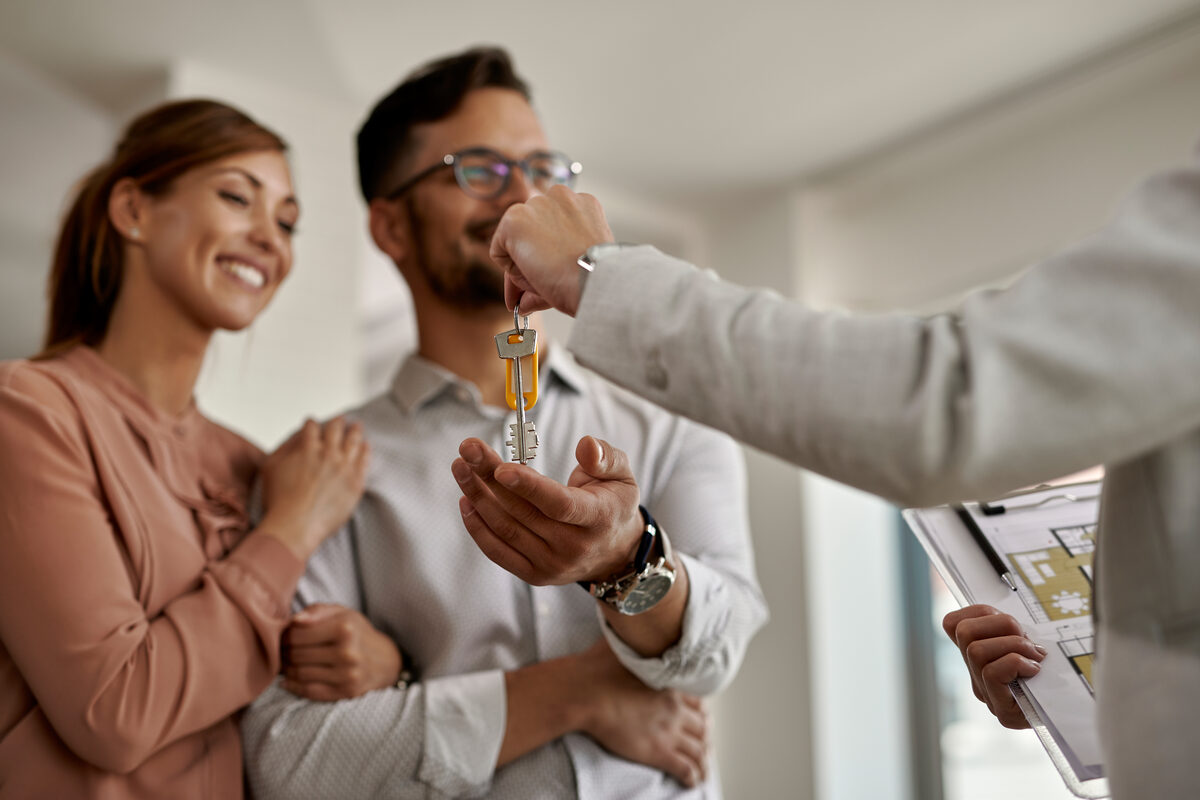 Estate agent handing over keys to new homeowners
